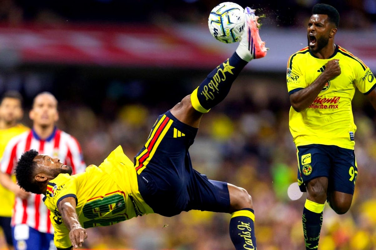 Miguel Borja y un compañero del América, de amarillo, celebran el empate; camisetas de las Águilas a color