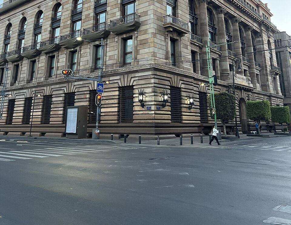 Personas caminan frente a la esquina del edificio del Banco de México