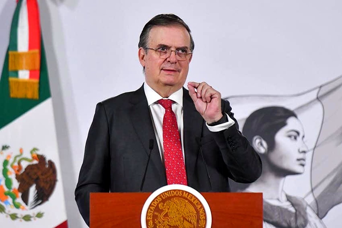 Marcelo Ebrard Casaubón, secretario de Economía, en tribuna, con la bandera nacional