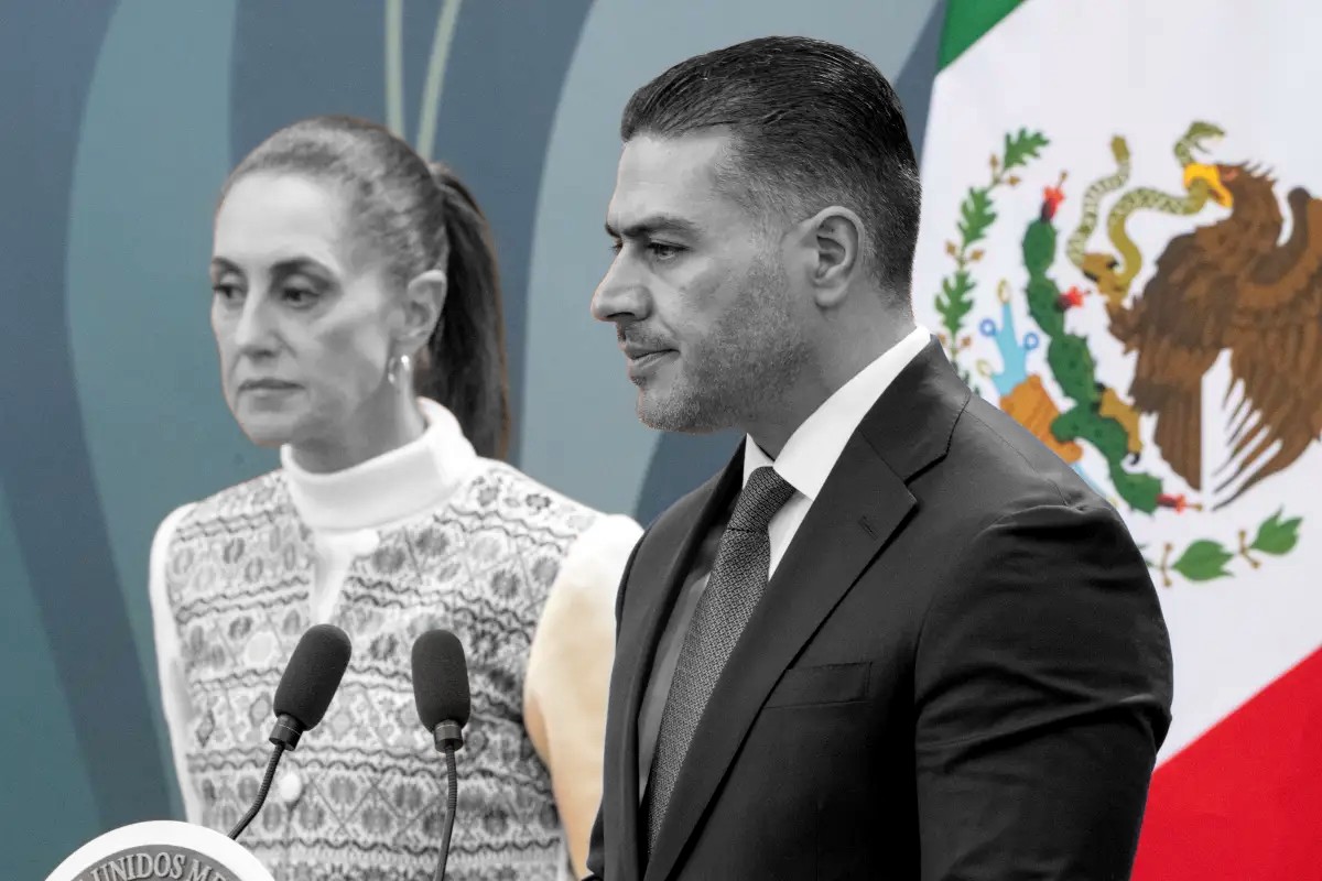 Omar García Harfuch, en escala de grises, habla al micrófono; detrás, Claudia Sheinbaum. Banderas y recinto en color