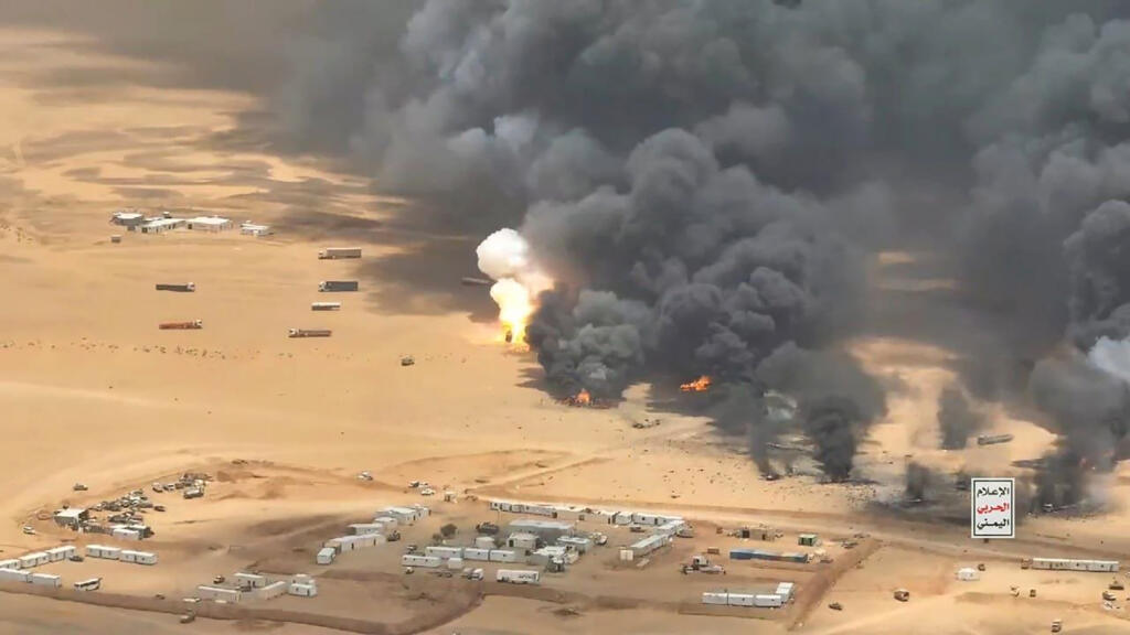 Columnas de humo negro y fuego en un campamento del desierto de Yemen, a color