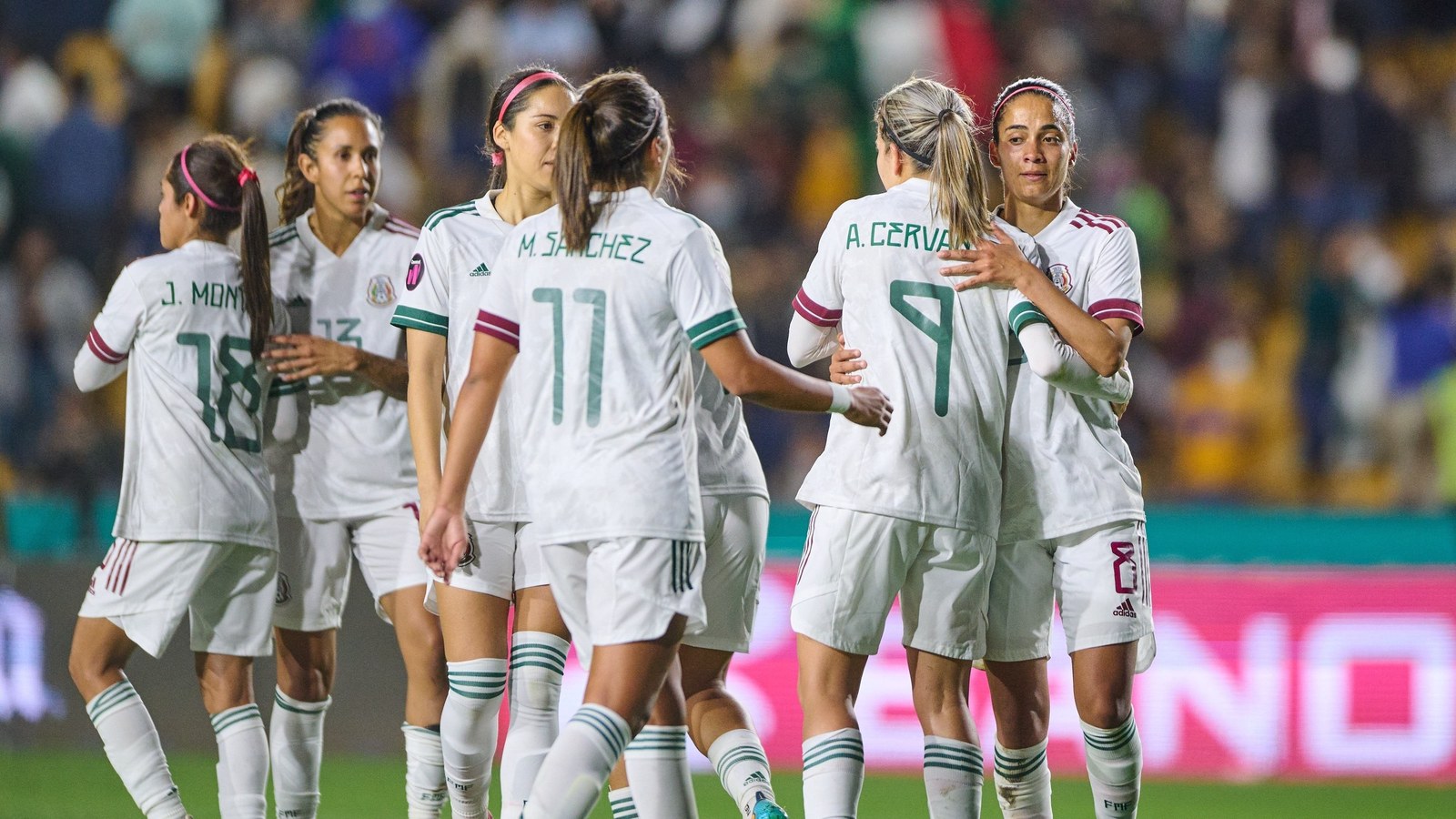 Jugadoras de la Selección Mexicana femenil de blanco celebran en la cancha, gradas al fondo