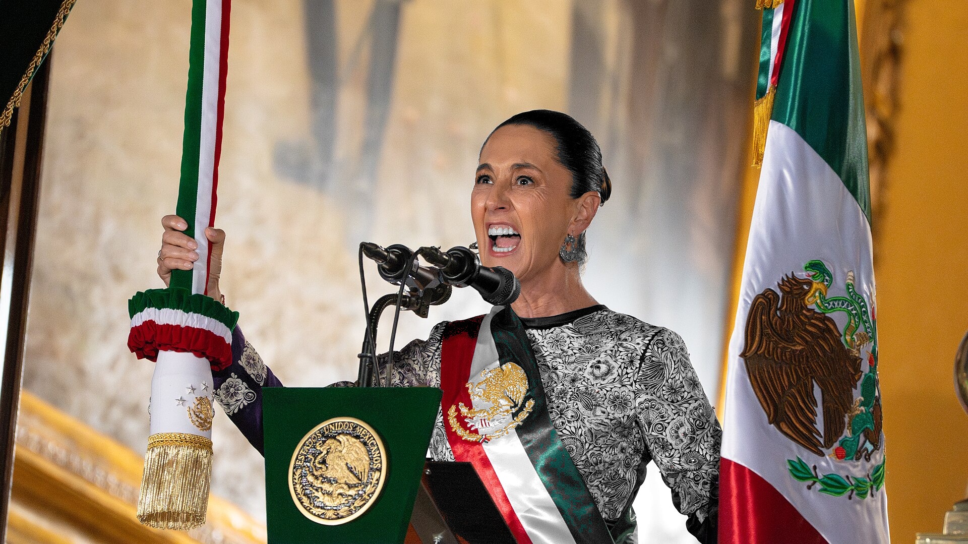 Claudia Sheinbaum, en escala de grises, da el Grito desde el balcón de Palacio Nacional; bandera y recinto a color