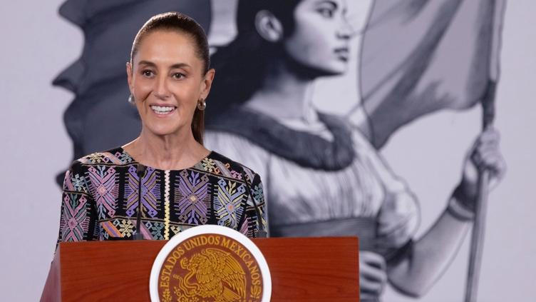 Claudia Sheinbaum, de huipil blanco con bordado, habla en Irapuato; banderas y recinto a color