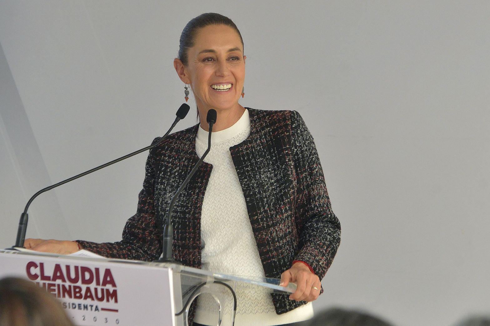 Claudia Sheinbaum Pardo habla en tribuna, con la bandera nacional al fondo