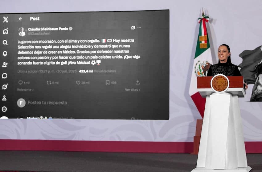 Claudia Sheinbaum, en escala de grises, en el podio de Palacio Nacional; bandera de México y pantalla a color