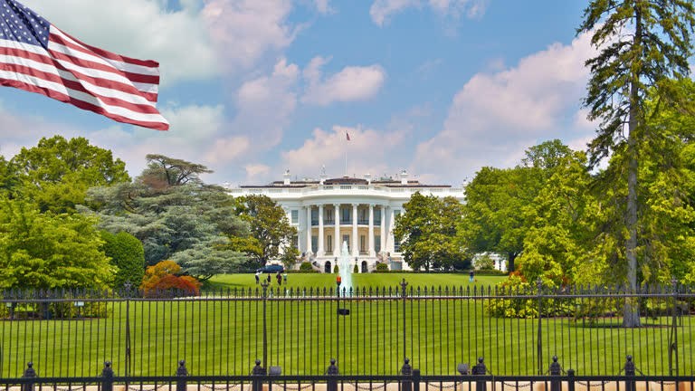 Casa Blanca y bandera de Estados Unidos a color, reja al frente