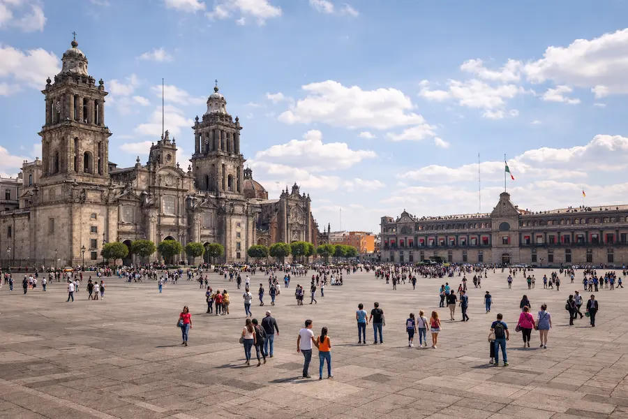 Plaza de la Constitución a color, Catedral y Palacio Nacional, gente en la plancha bajo cielo despejado
